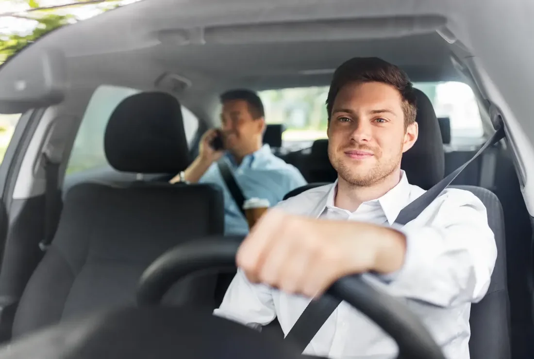 Driver wearing a fastened seat belt at the wheel of a vehicle