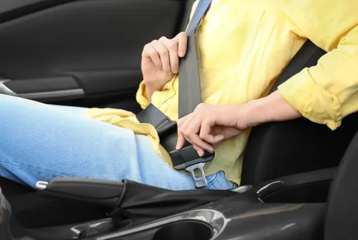 Occupant fastening a seat belt inside a vehicle during a routine inspection
