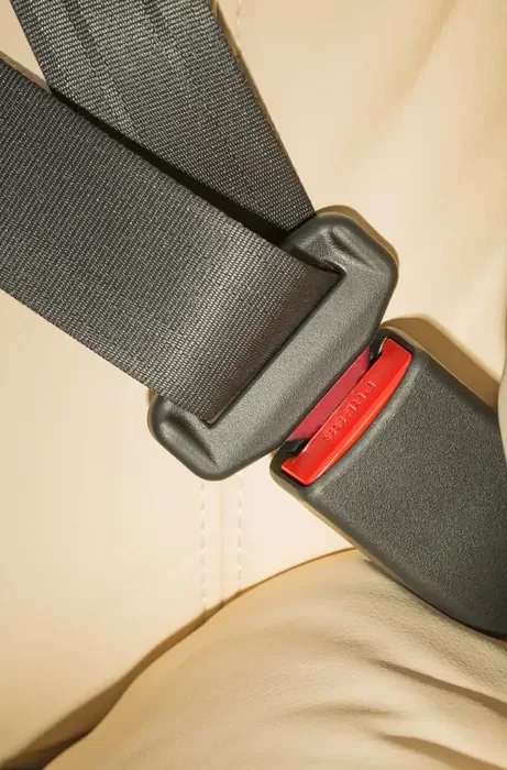 Seat belt fastened across a seat cushion with the buckle engaged